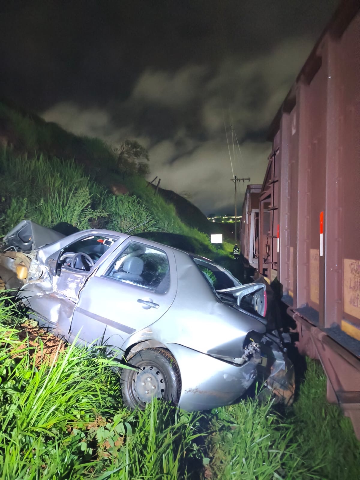 Um Carro (Fiat Siena) é arrastado por trem no bairro São João, em João Monlevade